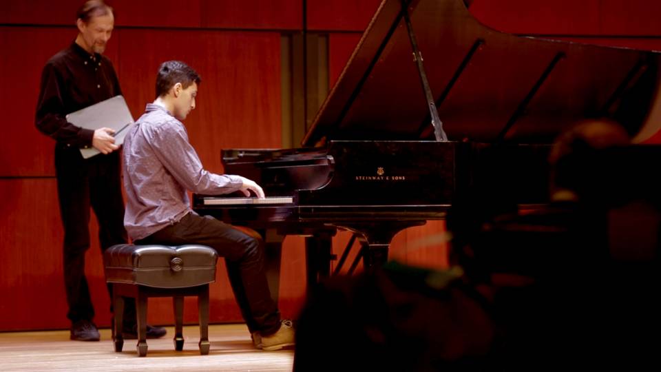 Student playing piano during master class