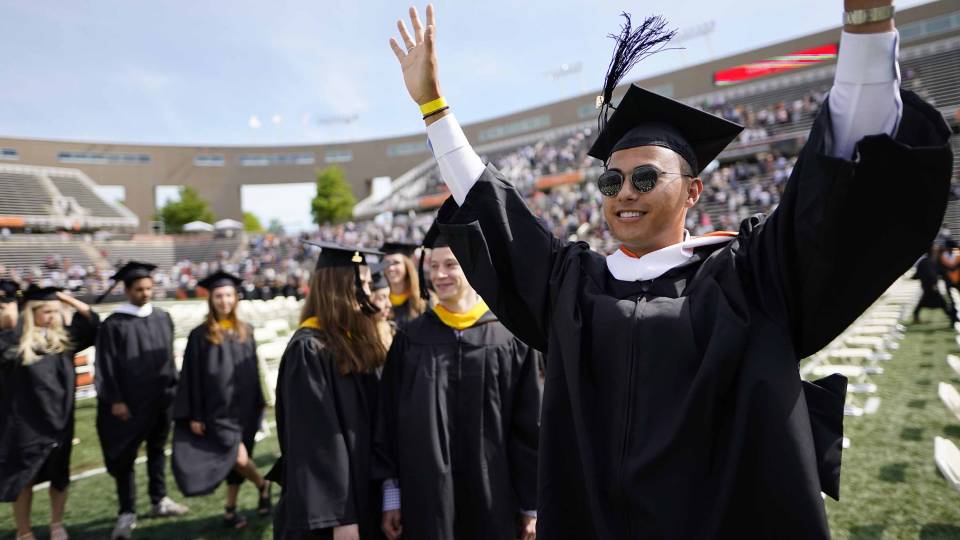 Graduating student waiving to the crowd