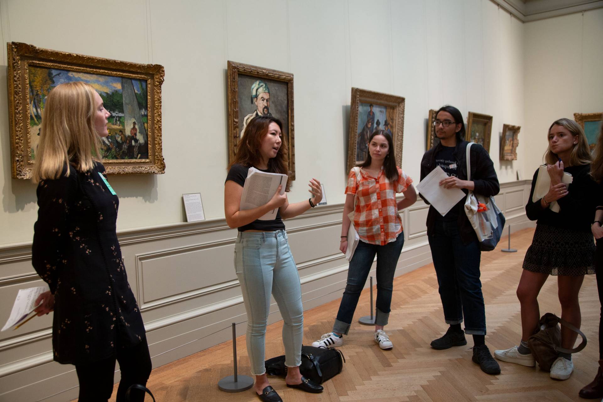 SuMin Park speaking to students in front of art